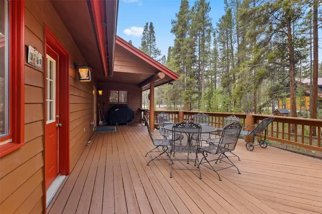 a view of a roof deck with table and chairs with wooden floor and fence