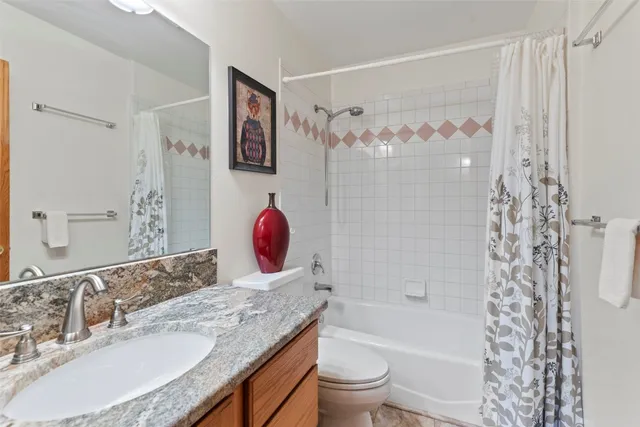 a bathroom with a granite countertop sink toilet and shower