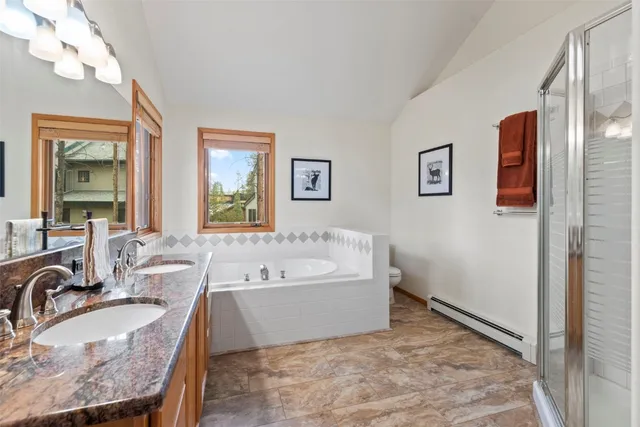 a spacious bathroom with a tub double sink and mirror