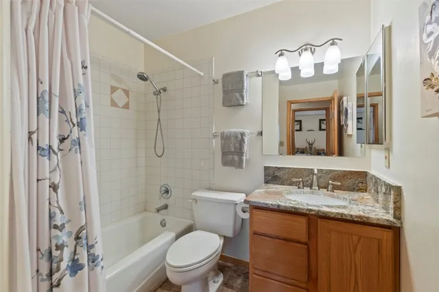 a bathroom with a granite countertop sink toilet and shower
