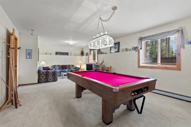 a room with pool table and windows