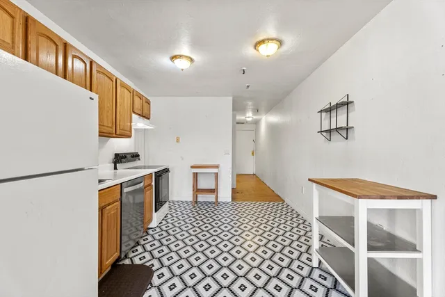 a bedroom with a bed and a refrigerator