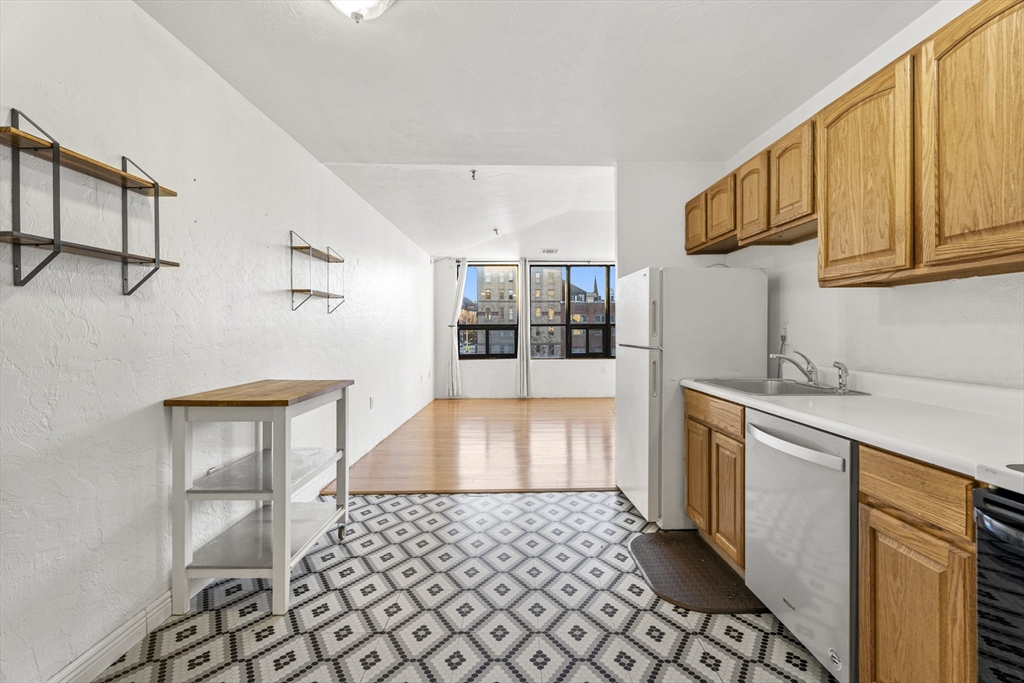 531 Main Street, Unit 403M Worcester, MA 01608 - Photo 14 of 39 a kitchen with stainless steel appliances a refrigerator and a stove top oven