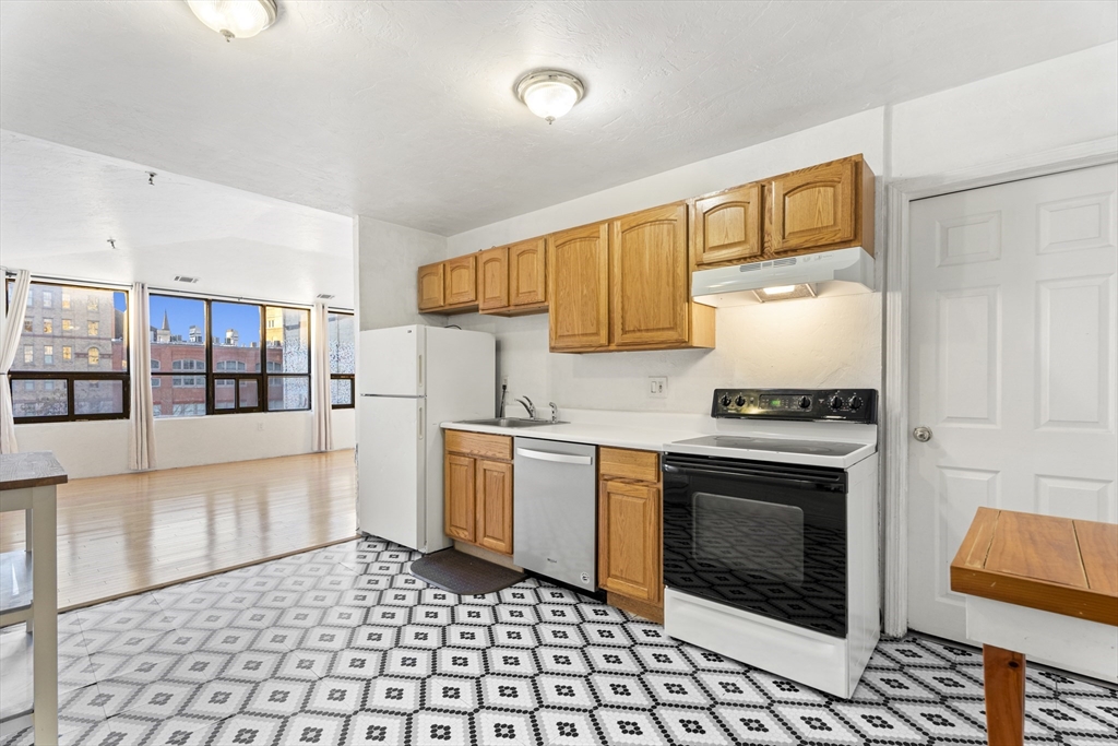 531 Main Street, Unit 403M Worcester, MA 01608 - Photo 16 of 39 a kitchen with stainless steel appliances granite countertop a stove a sink and a microwave