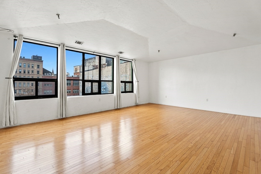 531 Main Street, Unit 403M Worcester, MA 01608 - Photo 2 of 39 a view of an empty room with window and wooden floor