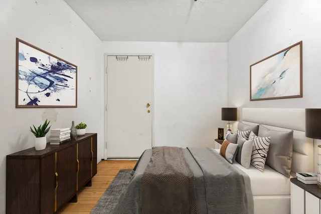 a bedroom with a bed and painting on the wall