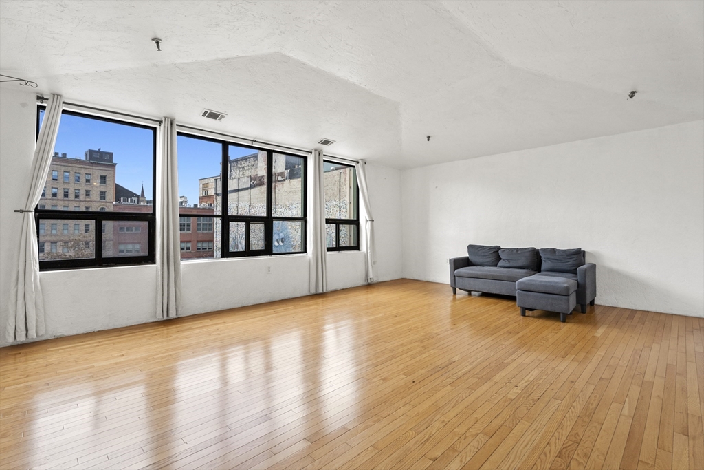 531 Main Street, Unit 403M Worcester, MA 01608 - Photo 3 of 39 a living room with furniture and a floor to ceiling window