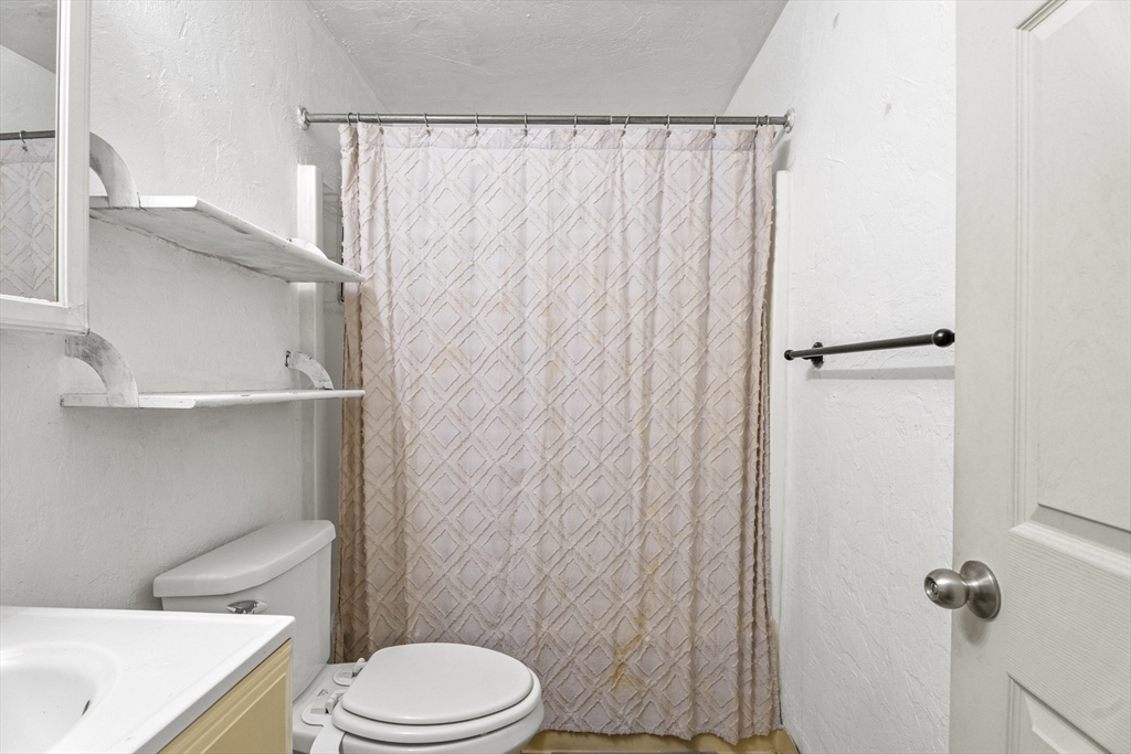 531 Main Street, Unit 403M Worcester, MA 01608 - Photo 34 of 39 a white toilet sitting next to a shower curtain