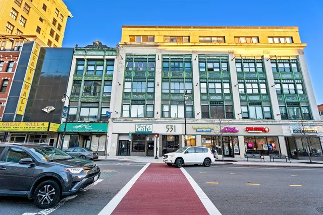 a view of building with cars parked