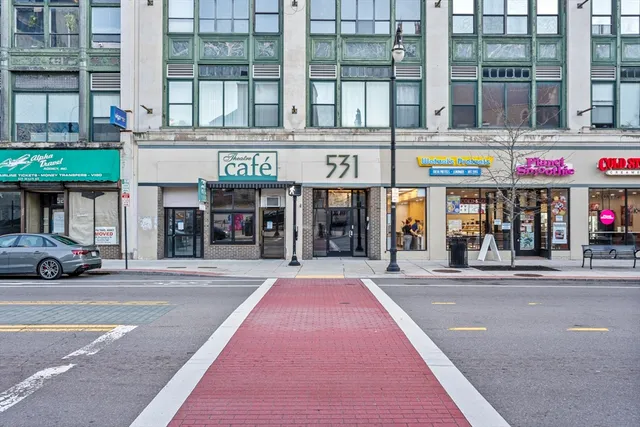 a front view of multi story building with retail shops