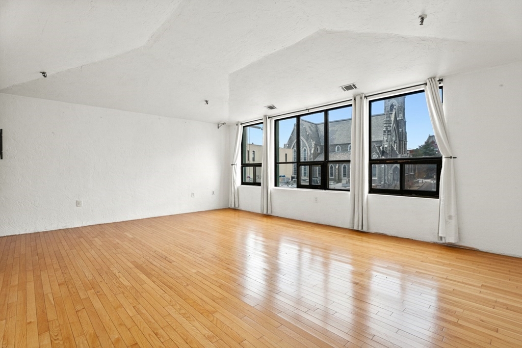 531 Main Street, Unit 403M Worcester, MA 01608 - Photo 4 of 39 a view of empty room with wooden floor and fan