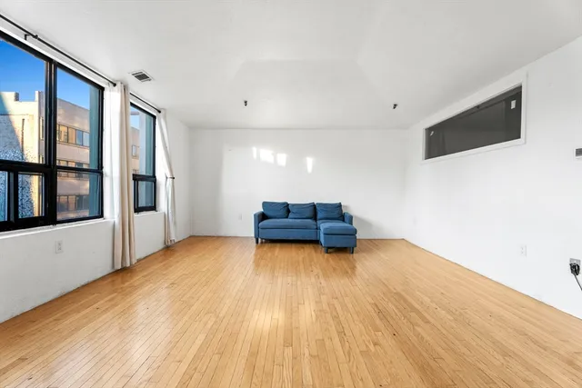 a big room with wooden floor and windows