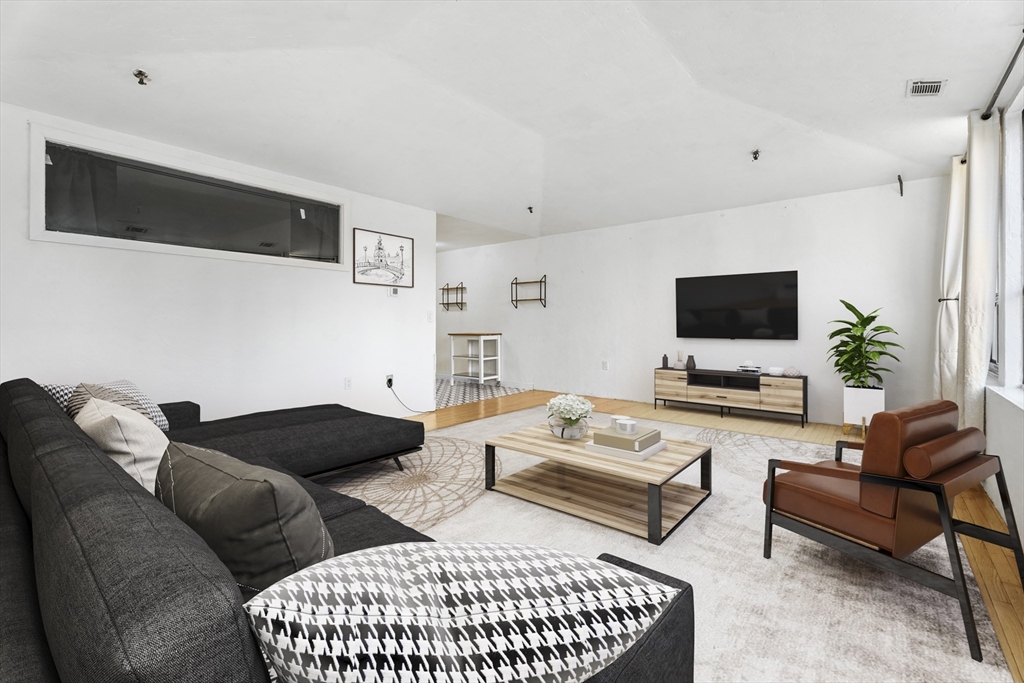 531 Main Street, Unit 403M Worcester, MA 01608 - Photo 8 of 39 a living room with furniture and a flat screen tv