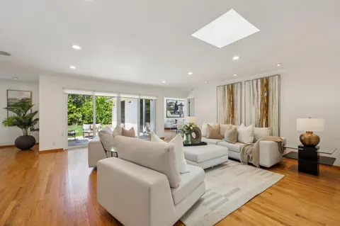 a kitchen with stainless steel appliances granite countertop a stove a sink dishwasher and cabinets with wooden floor