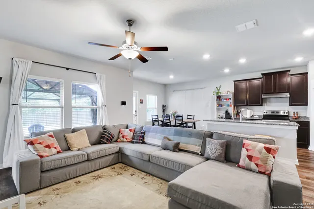 a living room with furniture a flat screen tv and a window