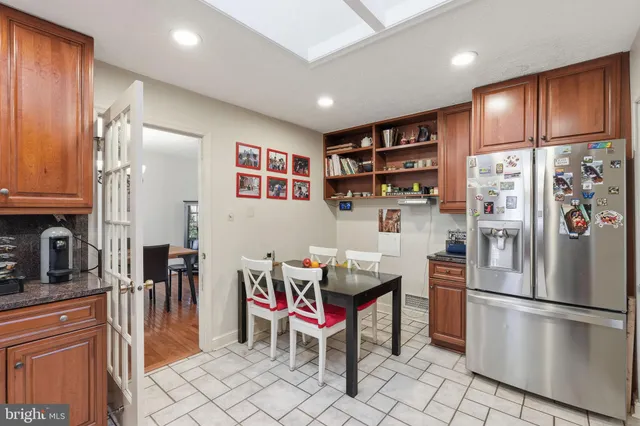 a kitchen with stainless steel appliances granite countertop a refrigerator and a stove top oven