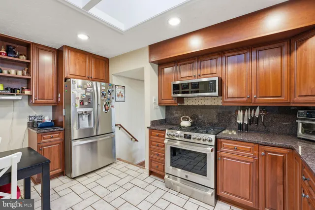 a kitchen with stainless steel appliances granite countertop a refrigerator stove and microwave