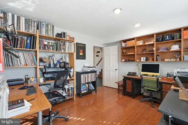 a view of a workspace with furniture and a bookshelf