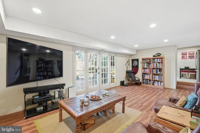 a living room with furniture a bookshelf and a window