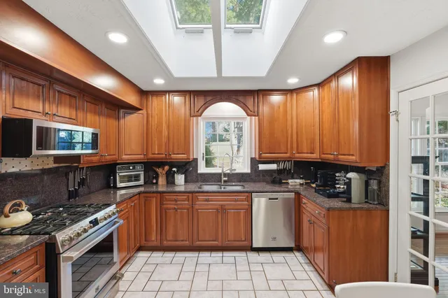 a kitchen with stainless steel appliances a stove sink and cabinets