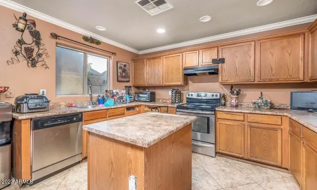 a kitchen with stainless steel appliances granite countertop a stove sink refrigerator and cabinets