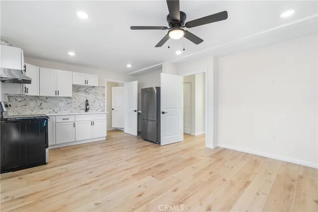 a large kitchen with stainless steel appliances a refrigerator and a stove top oven