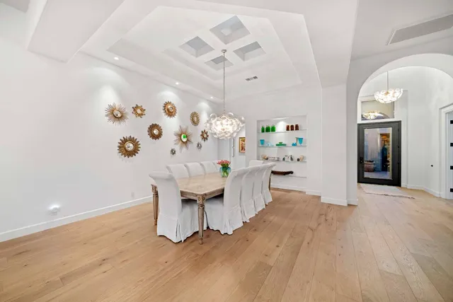 a kitchen with a table chairs a sink dishwasher stove and cabinets with wooden floor