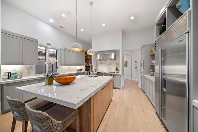 a kitchen that has a lot of cabinets a sink and wooden floor