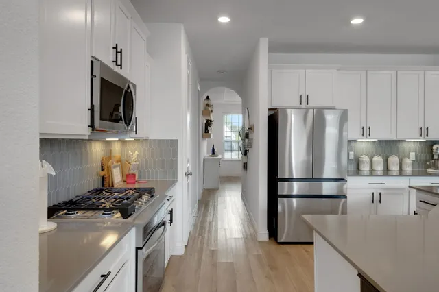 a kitchen with stainless steel appliances granite countertop a refrigerator stove and microwave