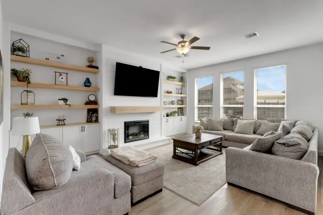 a living room with furniture a fireplace and a flat screen tv