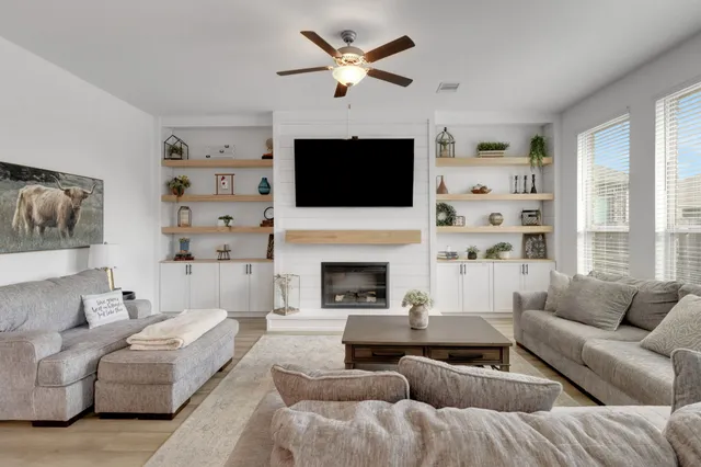 a living room with furniture a fireplace and a flat screen tv