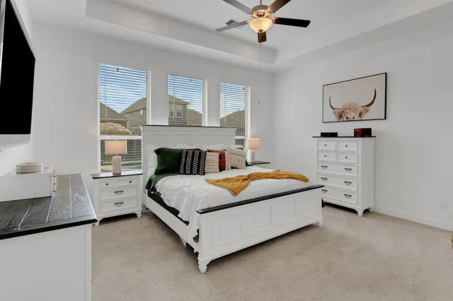 a spacious bedroom with a bed and a flat screen tv