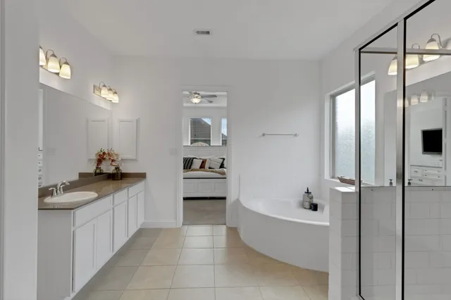 a bathroom with a granite countertop sink a mirror and a bathtub