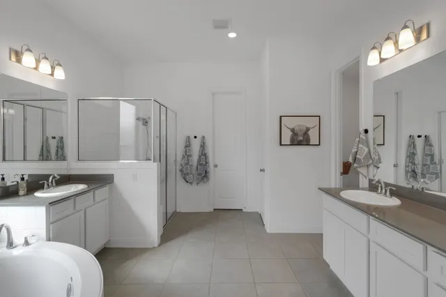 a bathroom with double vanity sink and a mirror