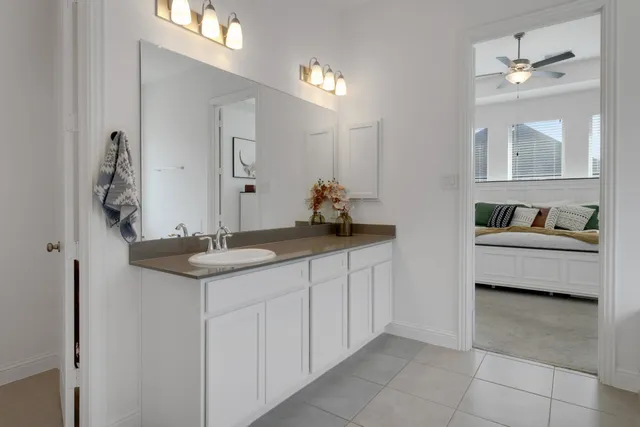 a en suite bathroom with a granite countertop sink and a mirror