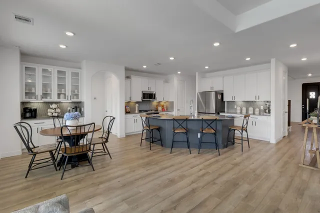 a view of a dining room with furniture wooden floor and a kitchen