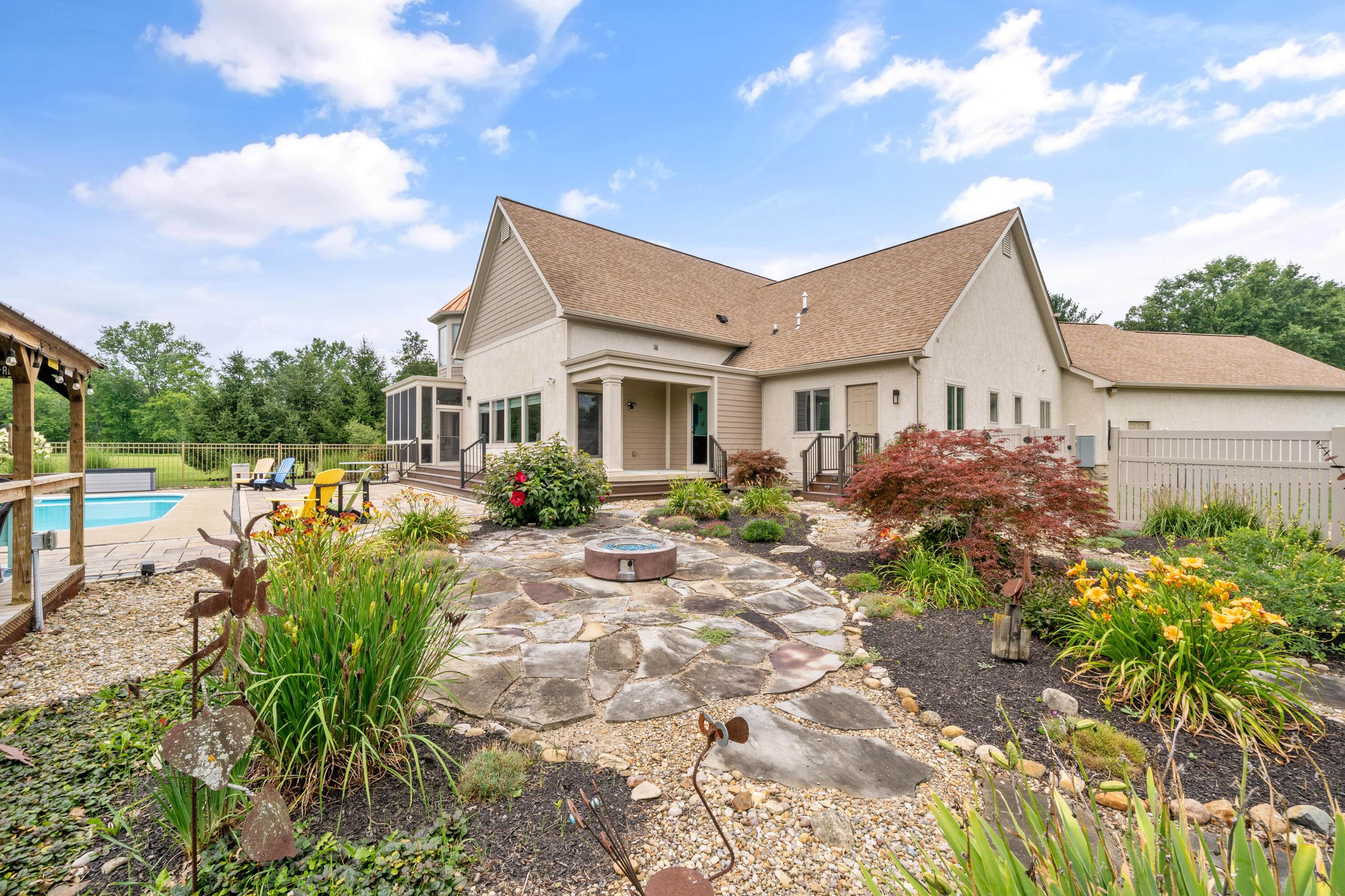 4640 Maynard Road Delaware, OH 43015 - Photo 64 of 91 Rear exterior featuring a stone patio, mature landscaping, and an inground swimming pool