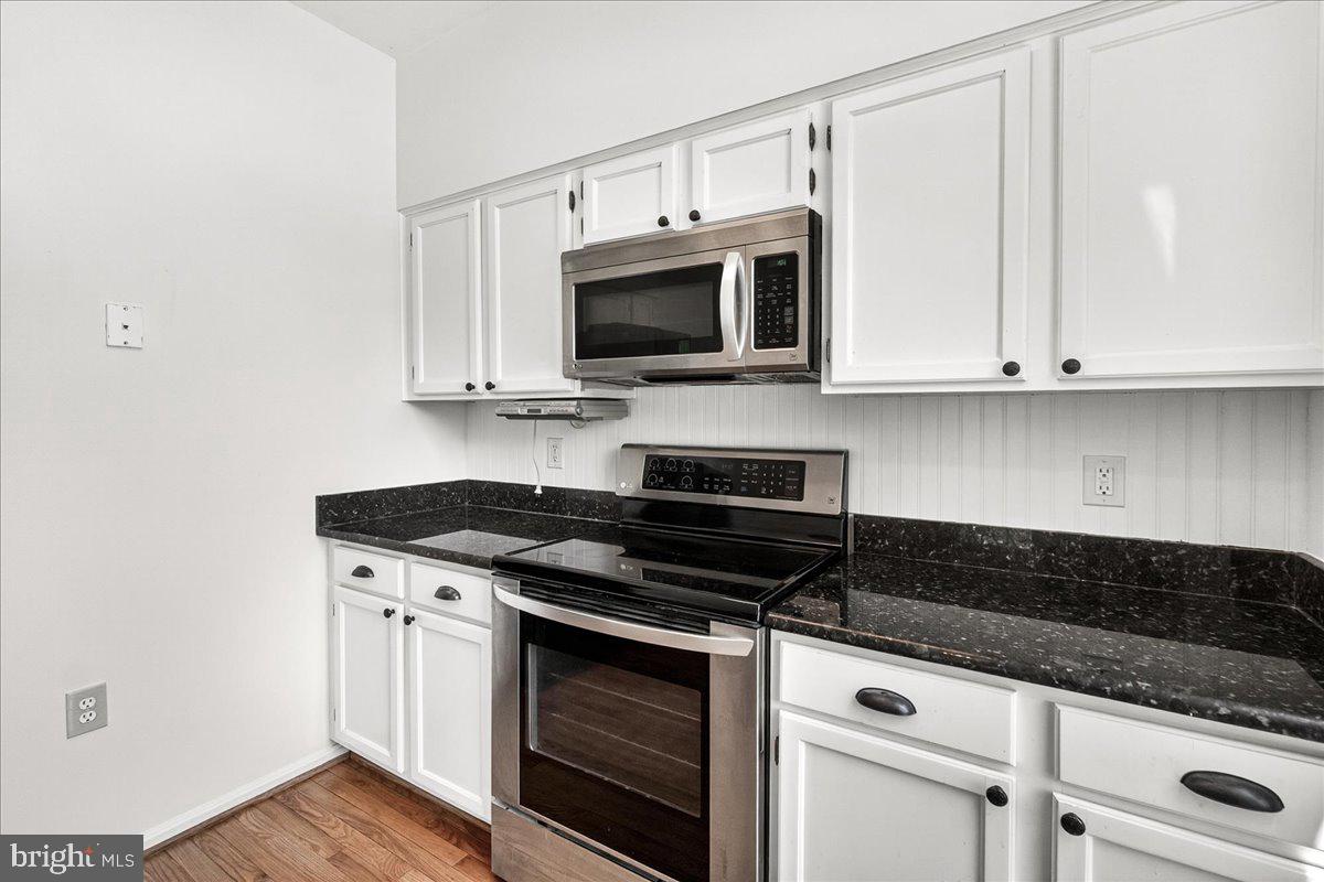 111 Water Land Way Frederick, MD 21702 - Photo 23 of 35 a kitchen with granite countertop a stove and a microwave