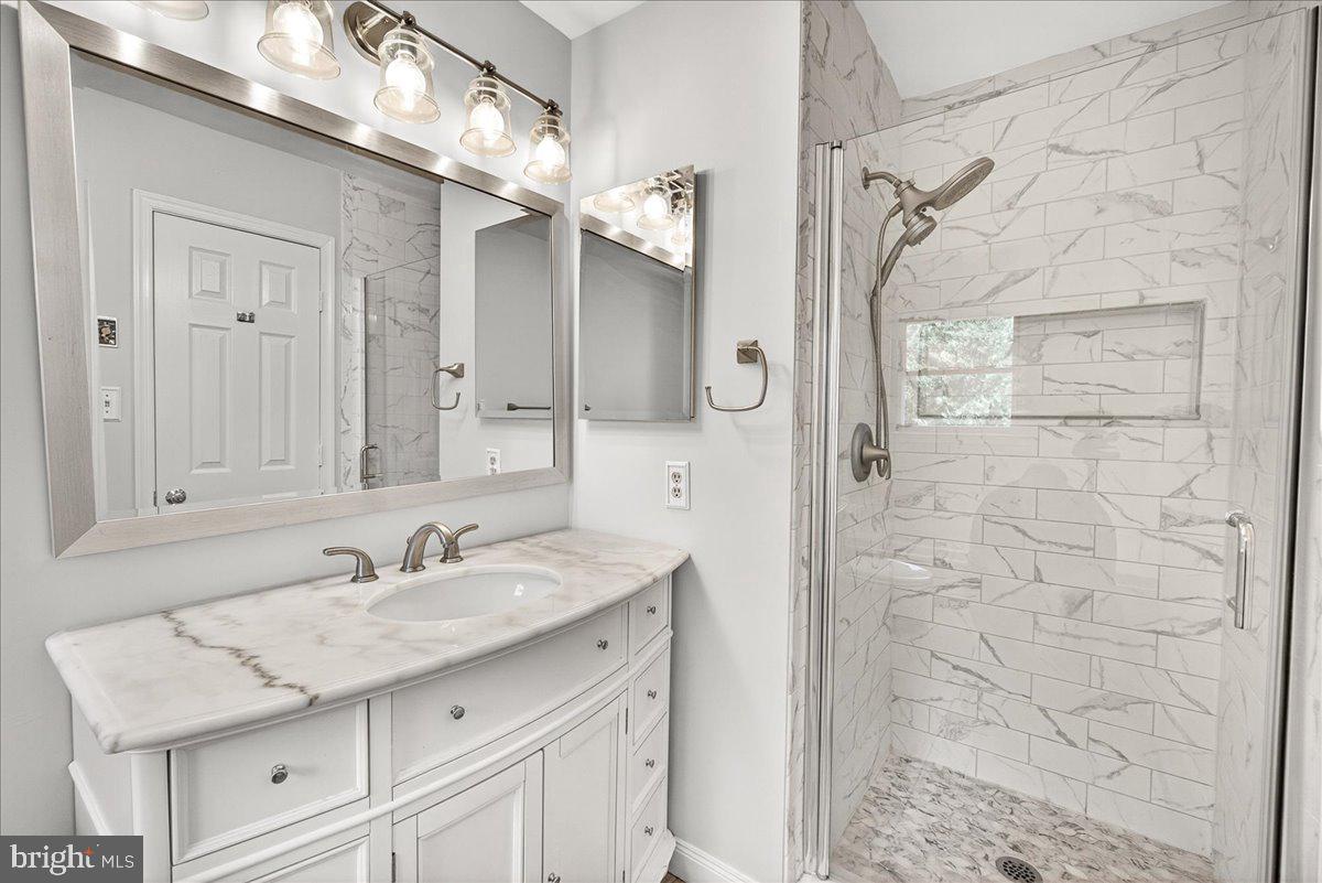 111 Water Land Way Frederick, MD 21702 - Photo 29 of 35 a bathroom with a sink vanity granite shower and a mirror
