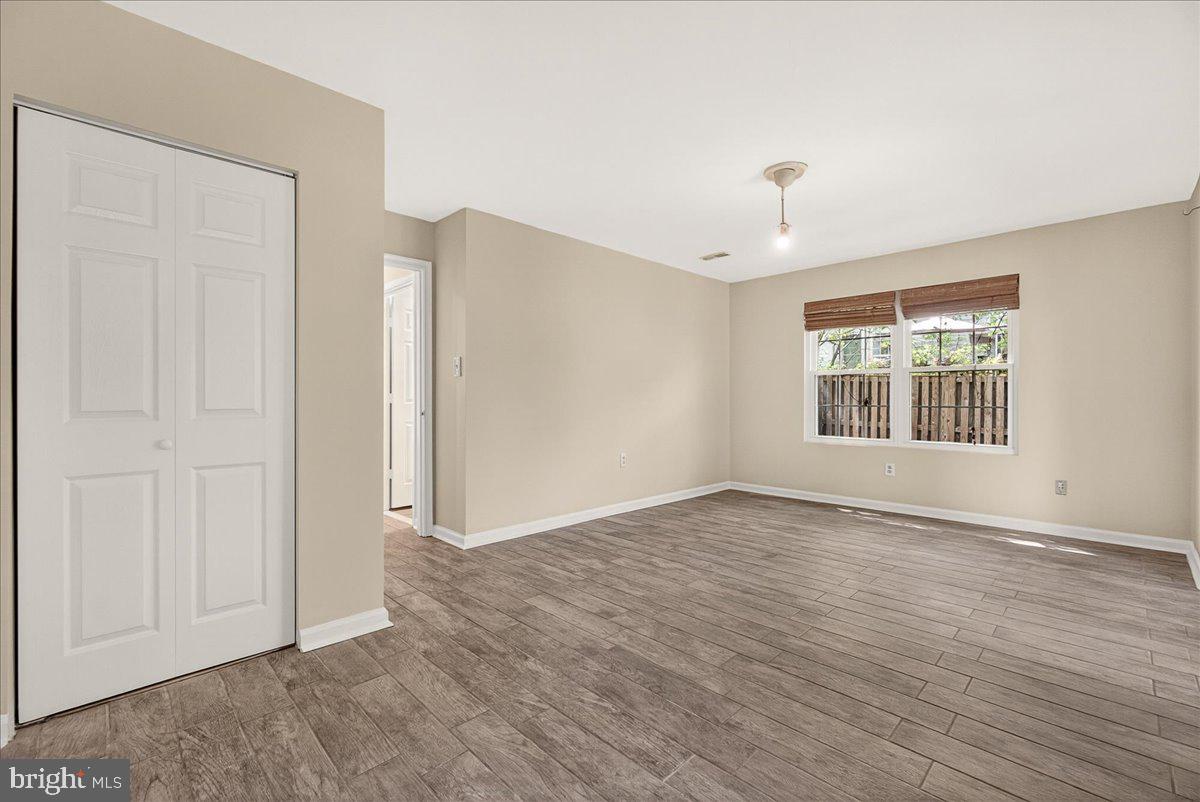 111 Water Land Way Frederick, MD 21702 - Photo 6 of 35 an empty room with wooden floor chandelier and windows