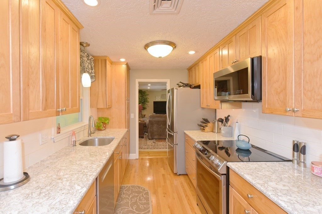 25 Edward Road Mendon, MA 01756 - Photo 6 of 42 a large kitchen with granite countertop stainless steel appliances a sink a counter top space and cabinets