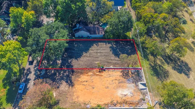 a view of a house with plants and large trees