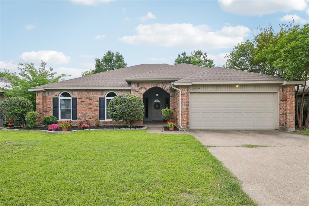 a front view of a house with a garden and plants