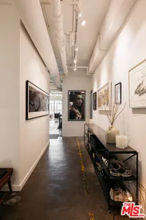 a hallway with a stove a dining table and chairs with wooden floor