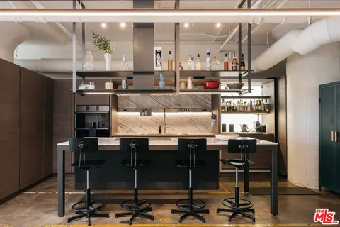 a kitchen with a table chairs and a wooden floor