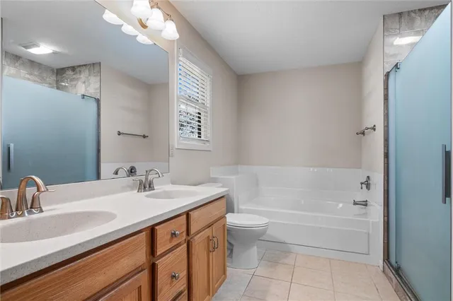 a bathroom with a sink a toilet a mirror a bathtub and shower