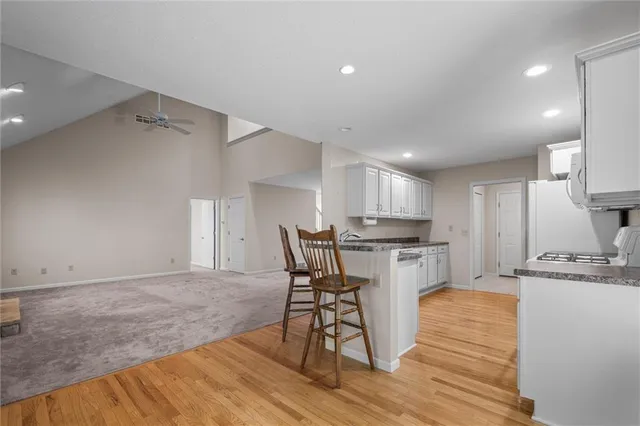 a kitchen with a table chairs refrigerator and cabinets