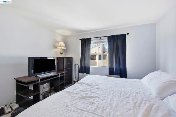 a bedroom with a bed next to a window