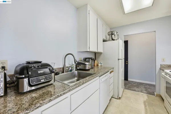 a kitchen with stainless steel appliances granite countertop a sink a stove and a refrigerator