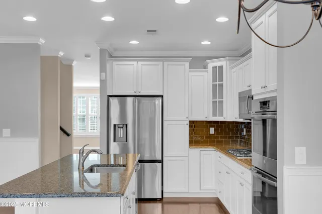 a kitchen with stainless steel appliances granite countertop a refrigerator and a stove top oven